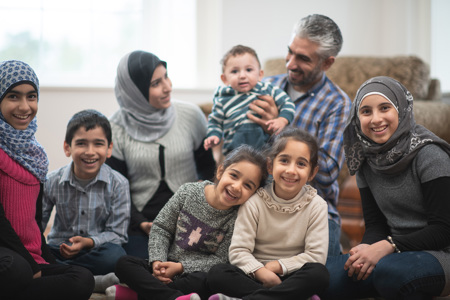 A big family sitting together on the ground.