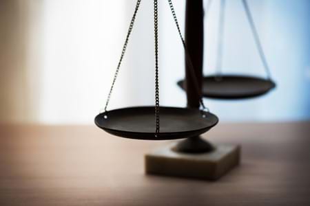 Focus on the scales of justice with a blurred background.