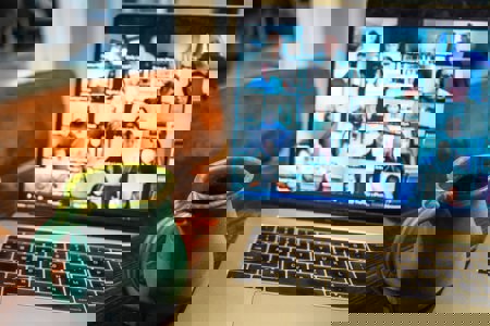 A person on a video call through their laptop talking with another person.