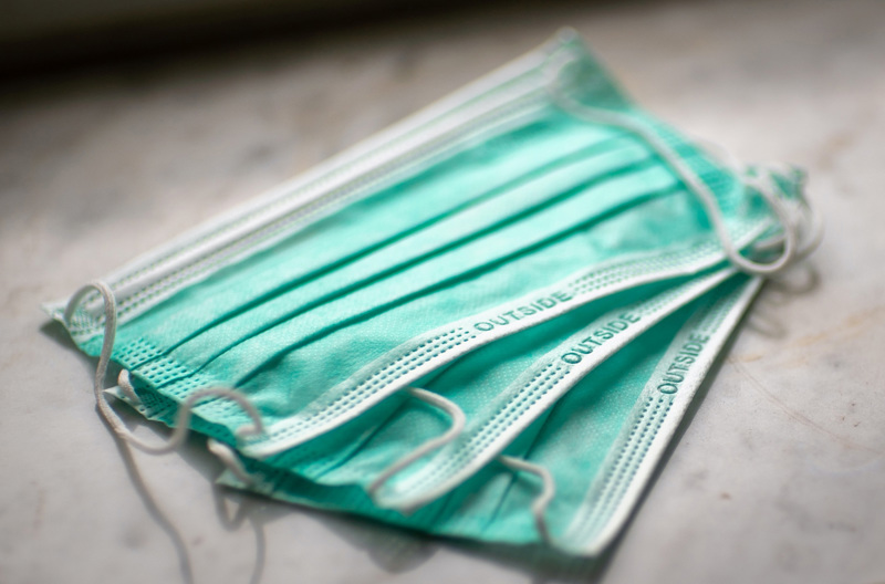 Disposable masks fanned out while stacked on top of each other.