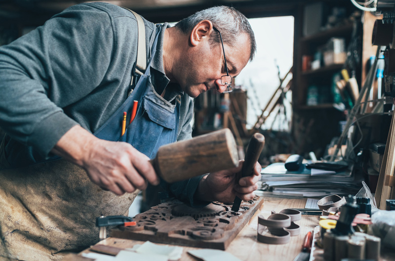 A man performing woodwork in a workshop.